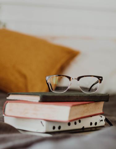 image of books and a pair of glasses on a table