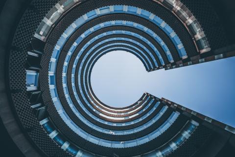 Looking up to sky through cylindrical building