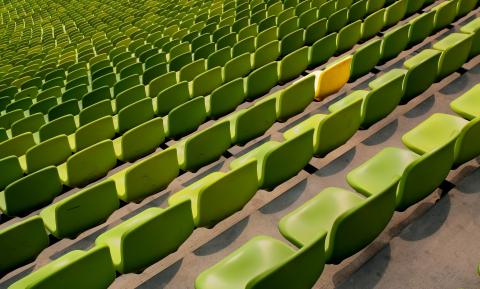 one yellow seat among green seats
